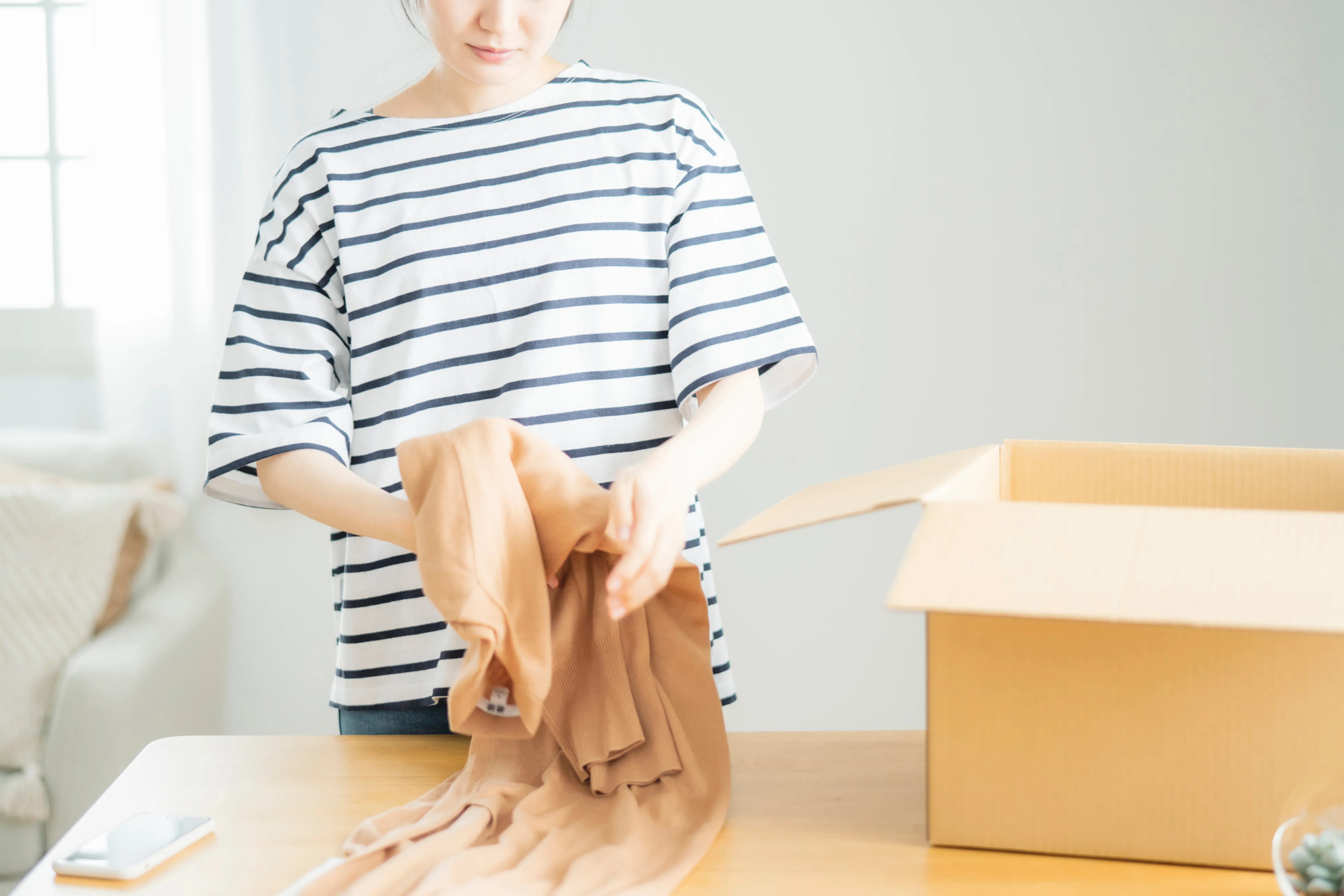 ダンボールに荷物を梱包する様子の写真